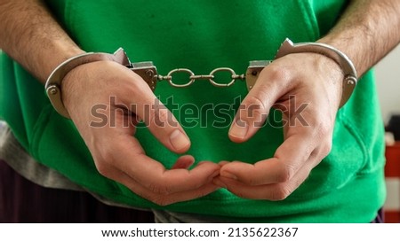 Arrest, Handcuffed criminal man hands close up. Hand cuffs locked in front, protection from crime and law violation.