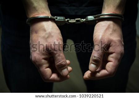 The arrested criminal handcuffed. Hands with handcuffs in the front