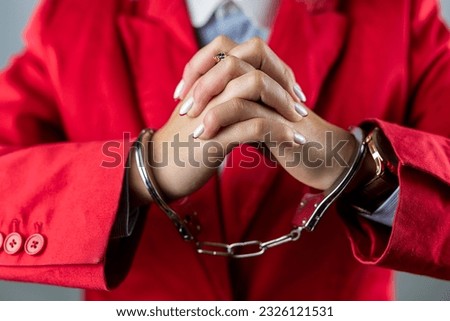 Arrested girl with hands in handcuffs with a huge amount of dollar bills. hands with dollars in handcuffs. girl in handcuffs
