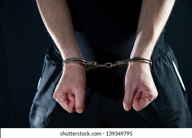  Arrested man handcuffed hands at the back - Shutterstock ID 139349795