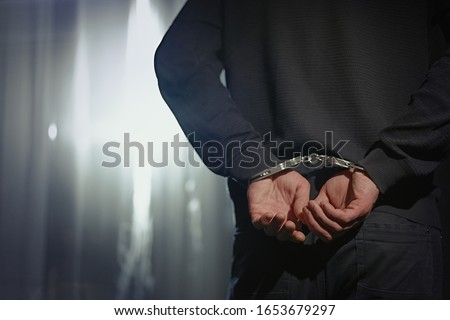 Arrested man handcuffed hands at the back                              