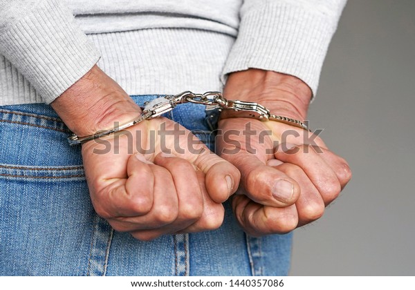 逮捕された男は手錠をかけた後ろ手を 捕虜か逮捕テロリスト 手錠をかけた手の接写 の写真素材 今すぐ編集