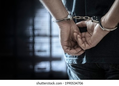Festgenommener Mann in Handschellen mit Handschellen hinter hinten im Gefängnis