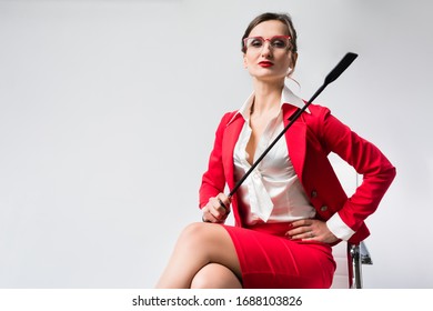 Arrogant Businesswoman With A Whip In Her Chair In The Office