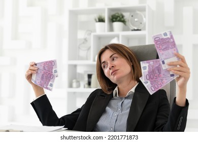 Arrogant And Confident Business Woman Holding Much Money Sitting In Her Office And Demonstrating Her Love To Cash