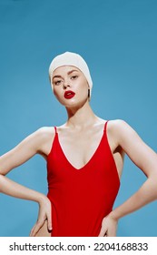 An Arrogant Female Model In A Bathing Cap In A Red Swimsuit Holds Her Hands At Her Waist, Looking At The Camera. Fashionable Conceptual Art Of Generation Z