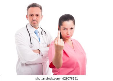 Arrogant Medical Nurse Showing Middle Finger Up In A Rude Gesture Near Serious Doctor On White Background