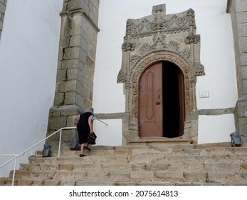 Arronches, Serra De Sao Mamede, Portalegre District, Portugal - October 10, 2021: Senior Woman Walking Up By Stairs Of Catholic Church