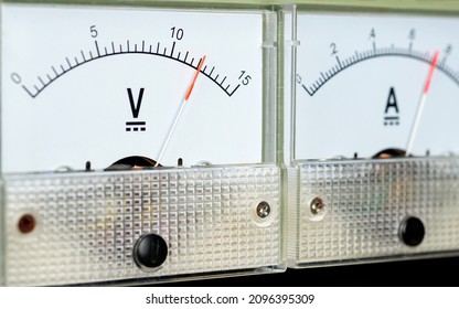 Arrow of the analog DC voltmeter shows the value of 12 volts.                 
