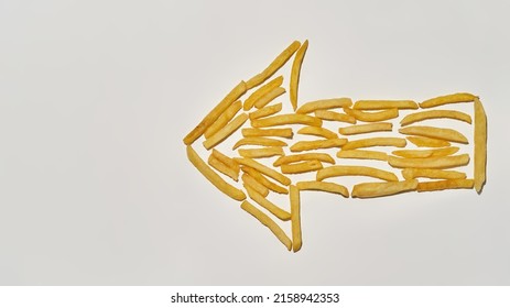 Arrow Gesture From French Fries Isolated On White Background. Unhealthy Eating And Fast Food. Fresh Cooked Tasty And Appetizing Snack For Leisure. Studio Shoot. Top View. Copy Space