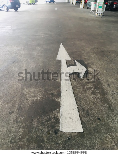 arrow on street is\
traffic sign in car park