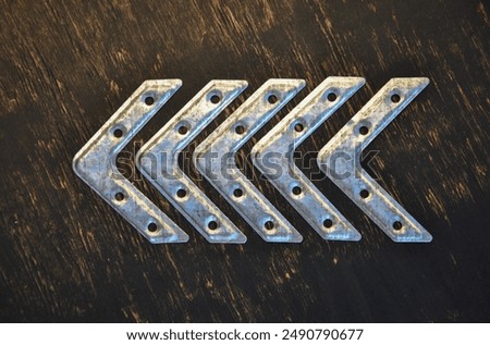 arrow pointer made of metal fastening corners on a dark background