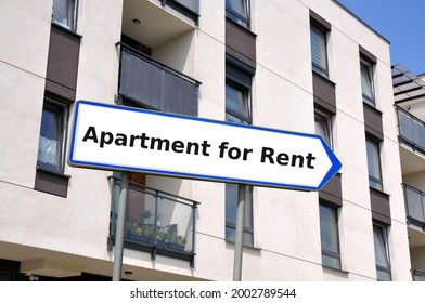 Arrow Shaped Sign Board Against The Apartment Building With The Inscription Apartment For Rent