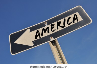 Arrow sign pointing down against a bright blue sky. Concept image of the direction that America is heading.