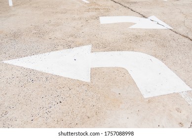 Arrow sign of turn, Old white painting on dirty concrete background.
