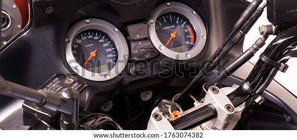 The\
arrow speedometer of a motorcycle on the steering wheel closeup.\
Colored dashboard with sport bike handles, top view. Horizontal\
image of a tachometer gauge. Banner for web\
site