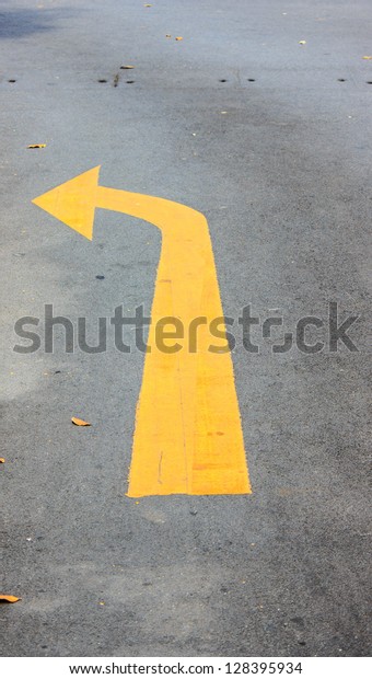 Arrow yellow turn\
left on road in sun shine