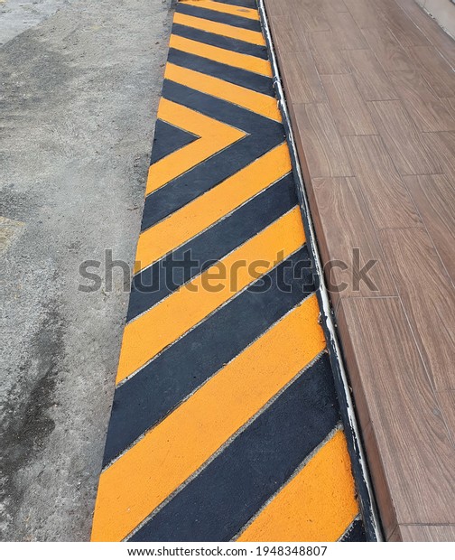 Arrow-like Yellow and black lines or yellow lines\
on curb or pedestrian lines are \