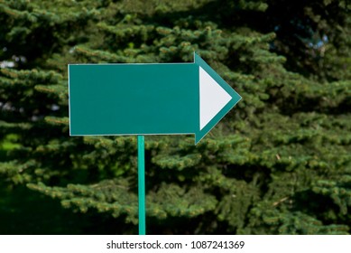 Arrow-pointer on the background of coniferous trees