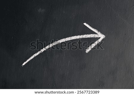 Arrows drawn by hand using white chalk on a gray wall background. Arrows drawn with white chalk.