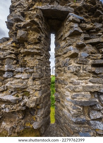 Arrowslit remaining in a wreckage of old castle (Wales, United Kingdom)