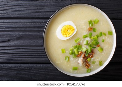 Arroz Caldo soup with rice, chicken and egg close-up in a bowl. horizontal top view from above