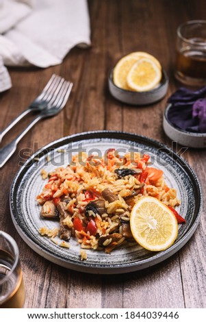 Arroz con verduras y azafran, spanish dish. Vegetarian risotto with  vegetables, champignons and saffron on wooden table. Selective focus