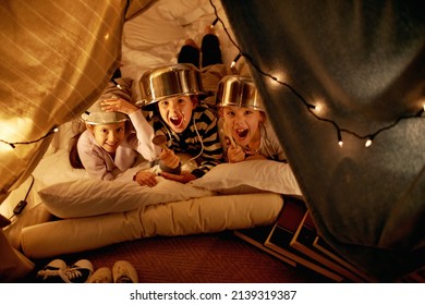 Arrrr. Shot of cute little children with pot helmets in a blanket fort.