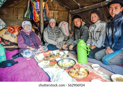 Arslanbob, Kyrgyzstan - circa July 2011: Native family sits on ground in their tent during lunch in Arslanbob, Kyrgyzstan. Documentary editorial.