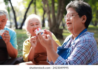 Art activities for the elderly. A group of elderly people sit and paint pots in the garden outside. They are happy. Living happily in retirement. art therapy - Powered by Shutterstock