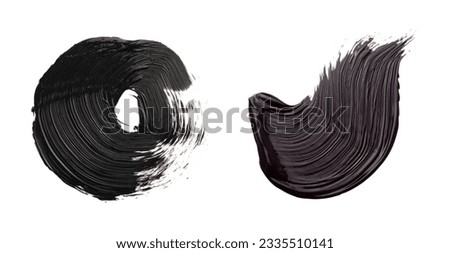 Brushstrokes of black oil paint on white background, top view