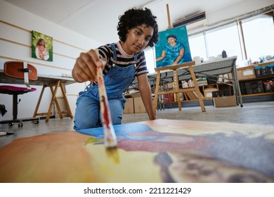 Art, creative and painter painting with watercolor and brush on a canvas at a table in a work studio. Indian design artist, woman or creativity student working as a designer with paint in a workshop - Powered by Shutterstock