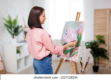 art, creativity and inspiration concept - back view of happy woman artist painting at home or studio - Powered by Shutterstock