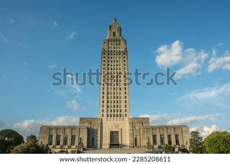 The Art Deco style Louisiana State Capitol seen from the Louisiana Capitol Garden with the cotton clouds and blue sky in downtown Baton Rouge, Louisiana, USA