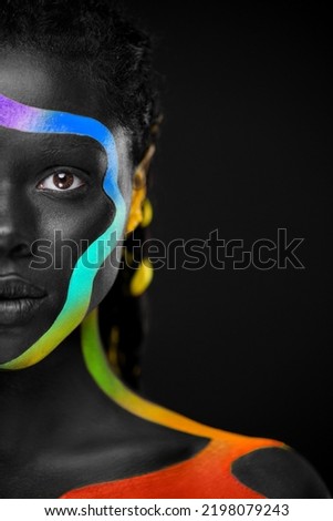The Art Face. Rainbow body paint on african woman. Abstract creative lgbtq portrait. Bright fashion makeup on the girl.