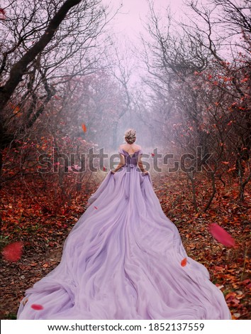 Art fantasy beautiful woman queen walk in autumn mystic forest, orange leaves bare trees. Magic light divine glowing in gothic fog. Girl lady princess. Medieval purple dress long train. back rear view