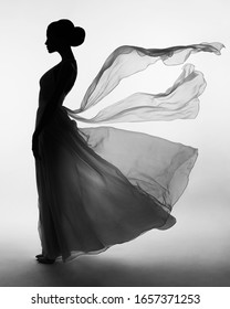 Art Fashion Studio Photo Of Beautiful Elegant Woman In Blowing Dress. Fashion Style Of Flowing Dress
