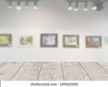 Art Gallery Of Creative Painting On The Wall With Wooden Table Foreground For Display Products Advertising Background 