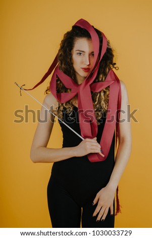 Art gymnastics with ribbon.Young beautiful atglete is posing in studio