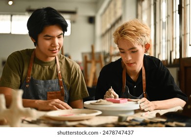 An art instructor observes and guides an LGBT student as they paint a ceramic piece. Both are engaged in the creative process in a well-lit studio filled with pottery tools and materials. - Powered by Shutterstock