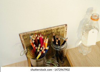 Art Material/pencils Standing In Pencil Holders Made From Household Waste. Glass Bottle And Metal Tin Can.