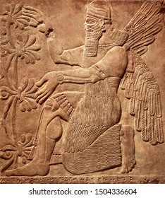 Art Of Mesopotamia, Monument Of Sumerian Civilization. Assyrian Wall Relief Of Winged God, Old Carving Panel From Middle East History. Remains Of Ancient Iraq Culture. Sumerian Sculpture Theme.