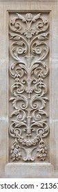 Art nouveau style carved panel on a building exterior. Ornate decorative panel with leaves and flowers. Traditional design in limestone. 
