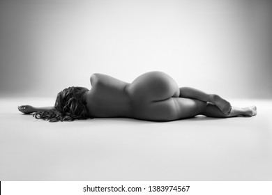 Art nude, perfect naked body, sexy woman on gray background, black and white studio shot, body positive concept