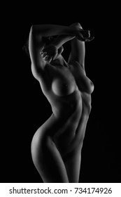 Art nude, perfect naked body, sexy young woman on dark background, black and white photography, studio shot