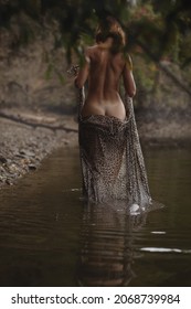 Art Nude woman standing near lake. Conceptual artistic photo of a sexy lady in a romantic