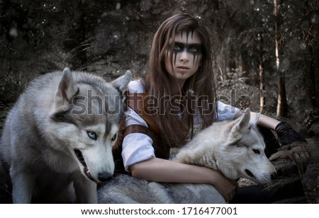 Art photo of a stern hunter with multi-colored eyes and two wolves