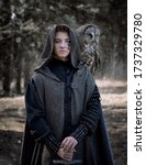 Art photo of a warlike youth in a woolen coat with a large owl on his shoulder