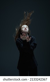 Art portrait of a beautiful young girl with long flying hair and closed eyes. The inner world of a human, emotions. Thoughtfulness, meditation. Studio portrait on a dark background. - Shutterstock ID 2133242367