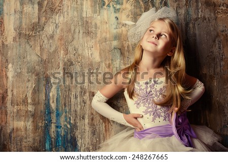 Art portrait of a pretty little girl wearing princess dress. Fashion shot. Childhood.